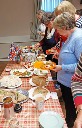Ladies decide what to choose from a table of cakes and other food