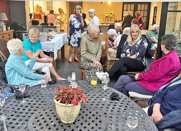 Several ladies sit around a table chatting