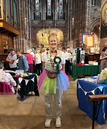 A lady stands in Shrewsbury Abbey with WI stalls around her
