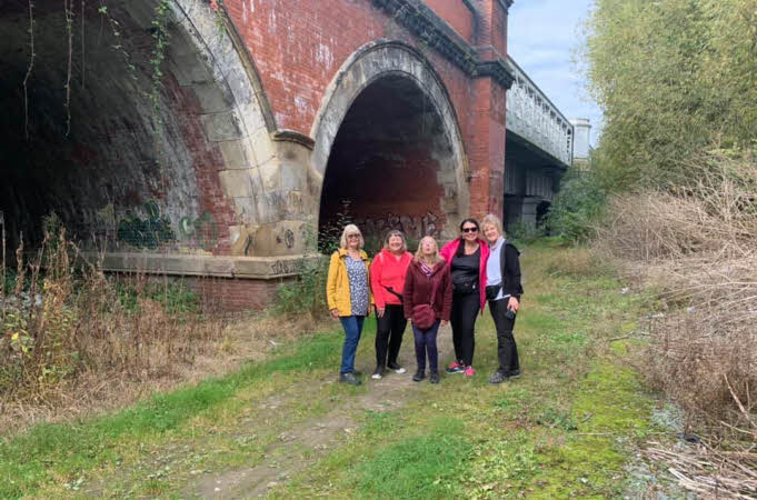 Five walkers near the railway arches by the station